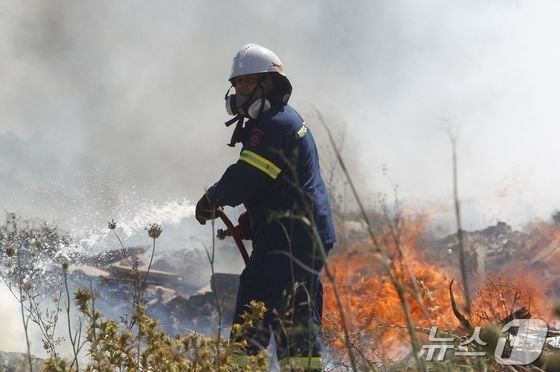 19일(현지시간) 그리스 아테네 외곽 도시 킫시에서 소방관이 산불을 진압하고 있다. 2024.06.19. © AFP=뉴스1 © News1 김민재 기자