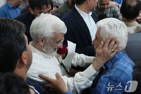 이란 대선후보 사이드 잘릴리(왼쪽)가 28일(현지시간) 대선 투표를 하기 위해 찾은 수도 테헤란 투표소에서 한 지지자와 포옹하고 있다. 2024.06.28 © AFP=뉴스1 © News1 권진영기자